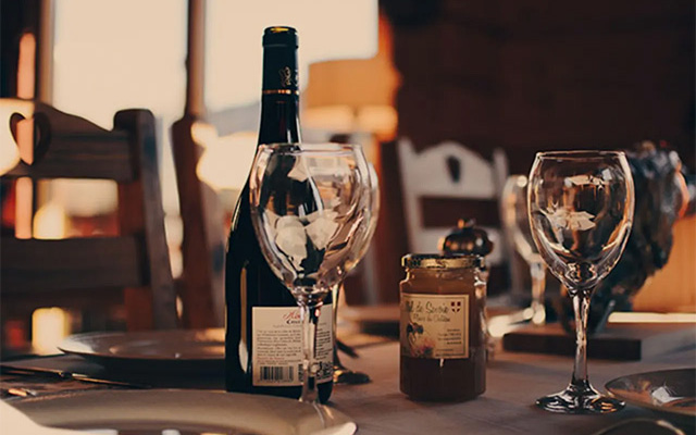 Wine on table with jars and glasses in dimply light room